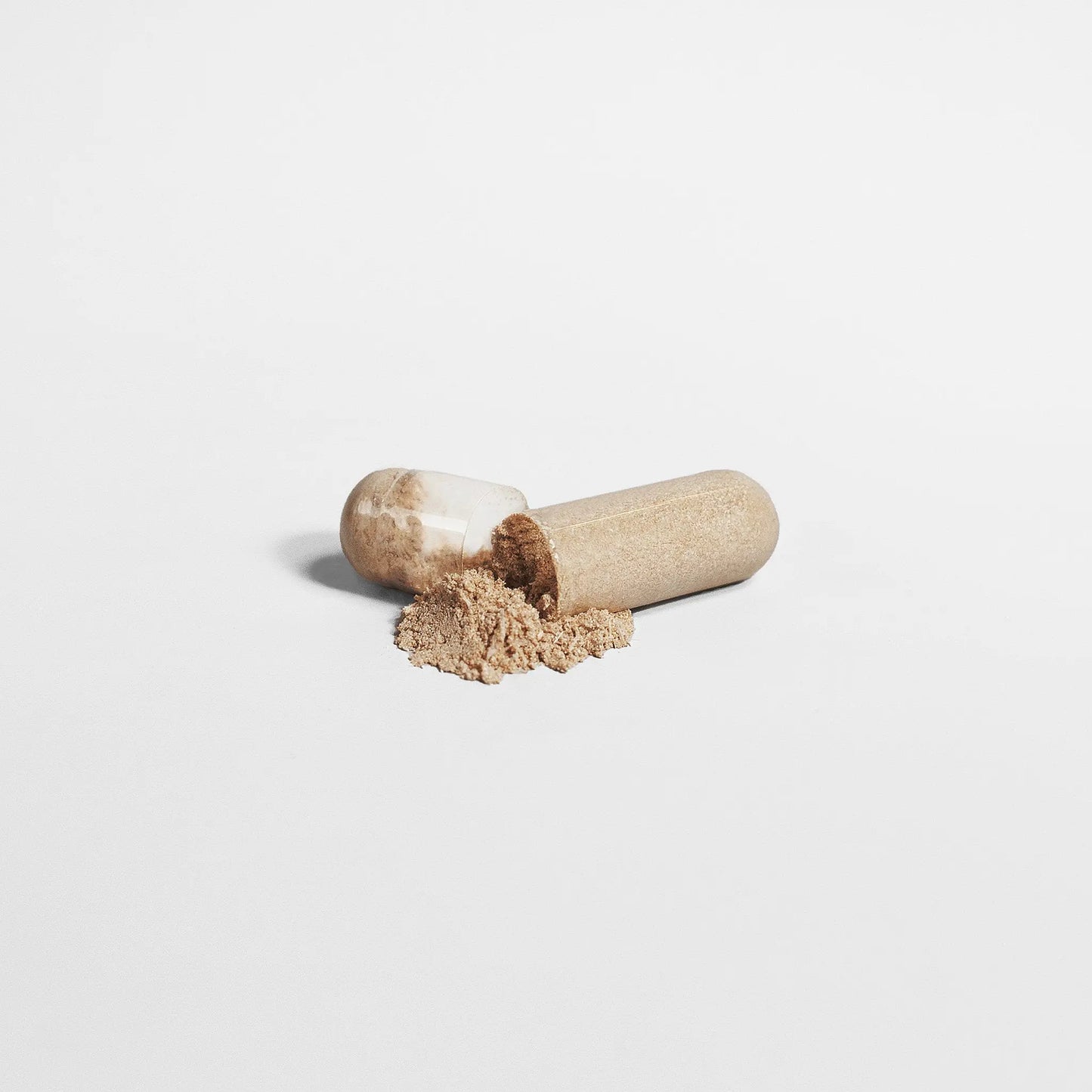 Mushroom Complex 10X Capsules opened with powder spilling out on white background