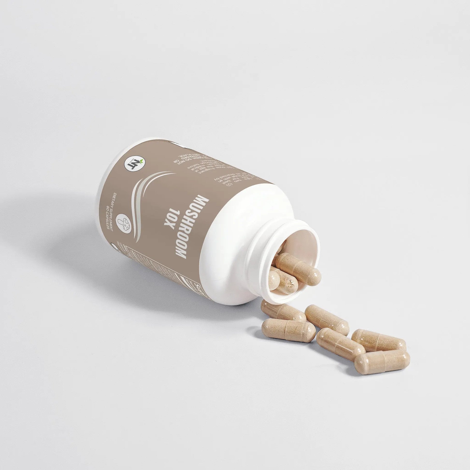 Mushroom Complex 10X Capsules spilling from an open bottle on white background.